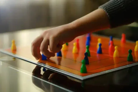Criança a jogar um jogo de tabuleiro